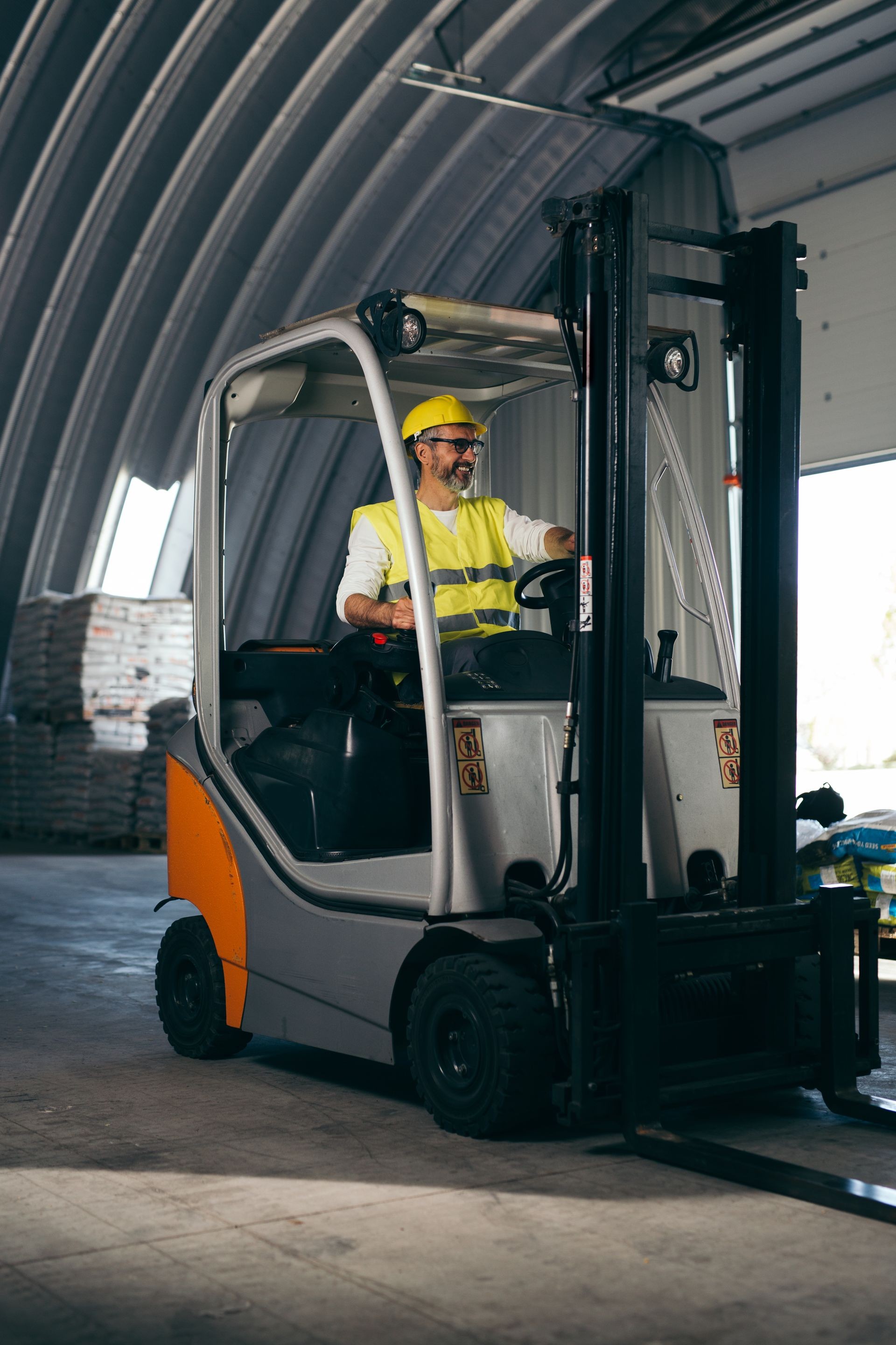 worker driving forklift in warehouse